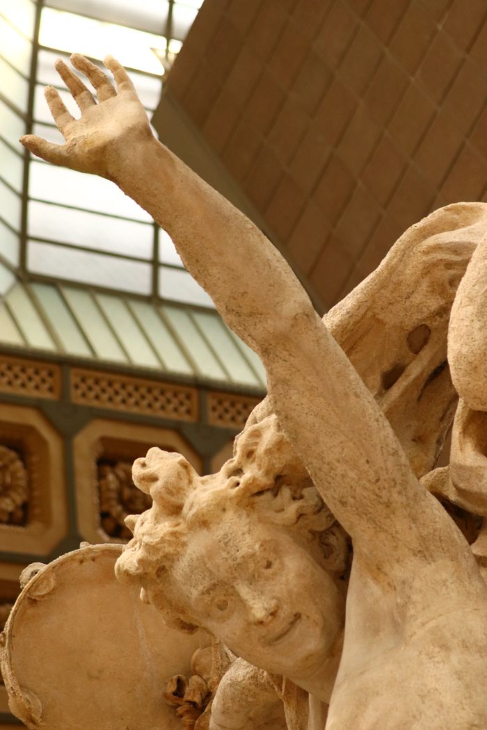 Close-up of a detailed ancient sculpture in a Paris museum.