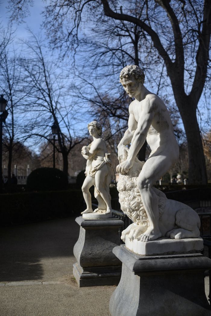 Elegant classical statues in a park setting in Valdemoro, Spain, on a sunny day.